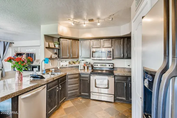 a kitchen with stainless steel appliances granite countertop a sink a stove and cabinets