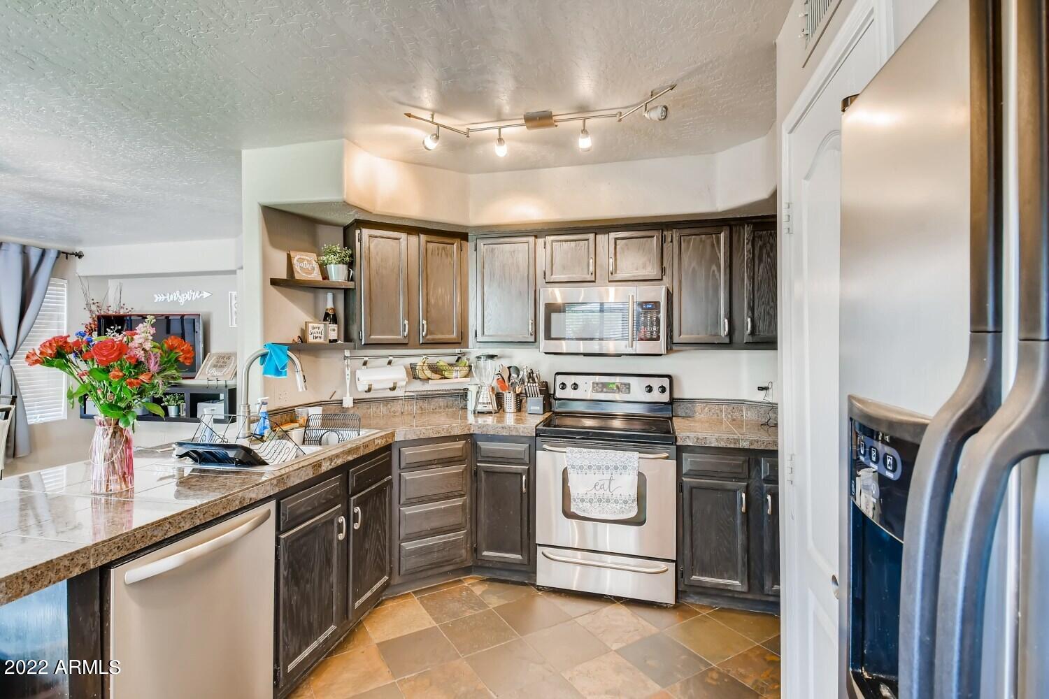 689 South Dodge Street Gilbert, AZ 85233 - Photo 6 of 28 a kitchen with stainless steel appliances granite countertop a sink a stove and cabinets