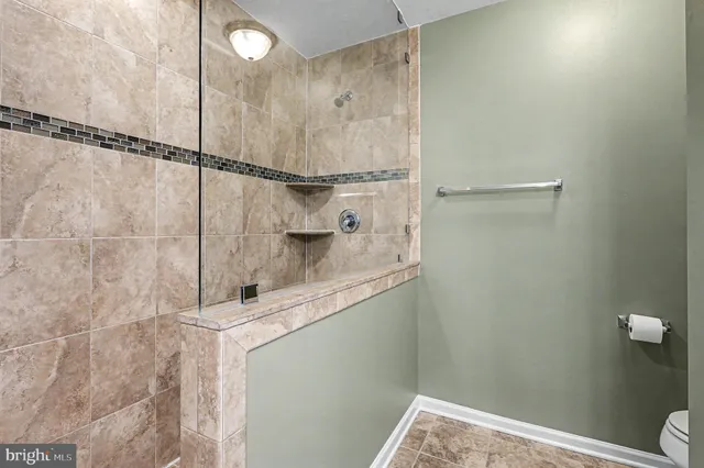 a bathroom with a granite countertop sink a toilet and shower