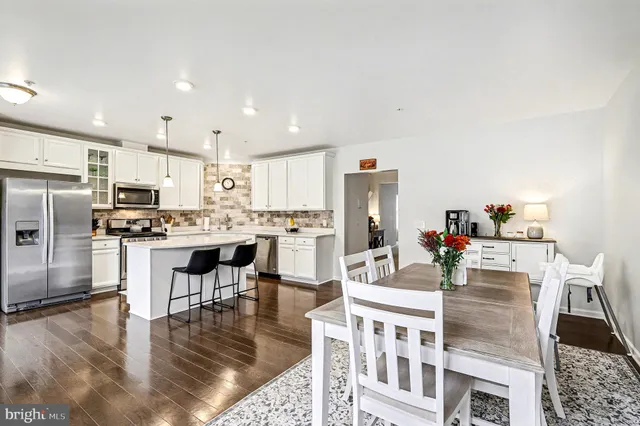 a kitchen with stainless steel appliances kitchen island granite countertop a refrigerator and a stove top oven