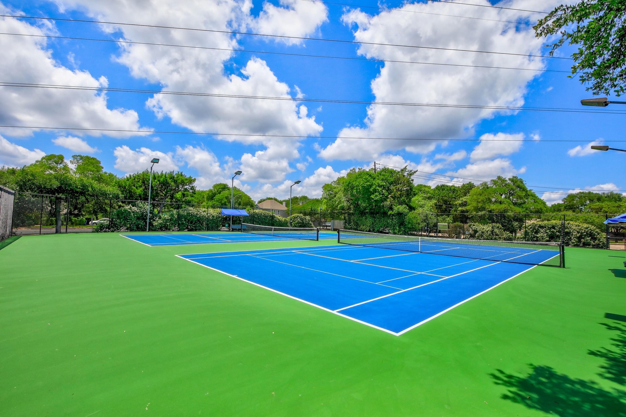 7705 Jester Boulevard Austin, TX 78730 - Photo 32 of 36 Sporting amenities include vibrant tennis courts, ready for competitive play under clear skies.