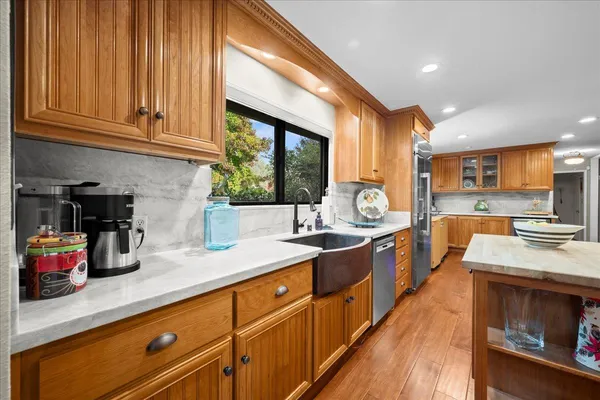 a large kitchen with stainless steel appliances granite countertop a lot of counter space and wooden floors