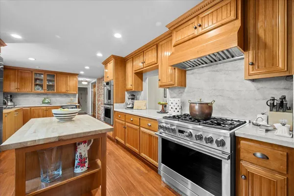a kitchen with stainless steel appliances granite countertop a stove a sink and a microwave
