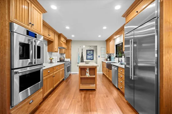 a kitchen with stainless steel appliances granite countertop a refrigerator a stove and a sink