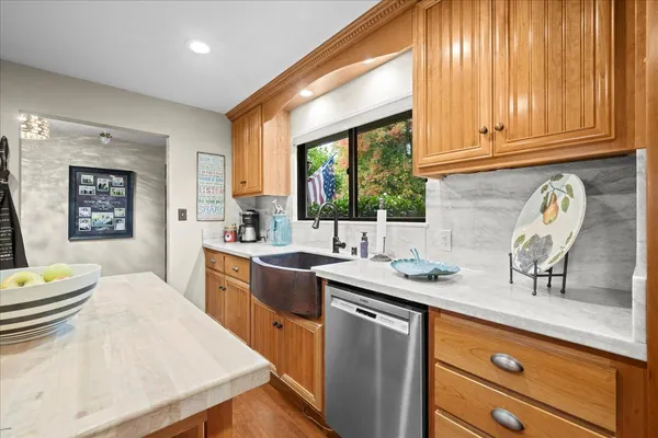a kitchen with stainless steel appliances granite countertop a sink a stove and a wooden cabinets