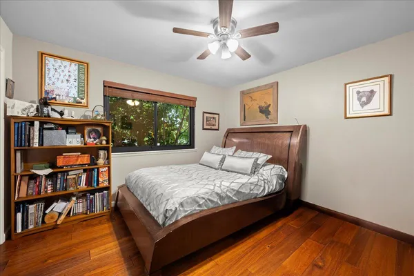 a bed sitting in a bedroom next to a book shelf