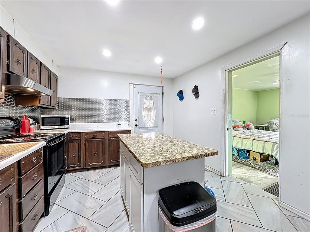 7717 Clarcona Ocoee Road, Unit LOT 1 Orlando, FL 32818 - Photo 13 of 36 a kitchen with a sink cabinets and window