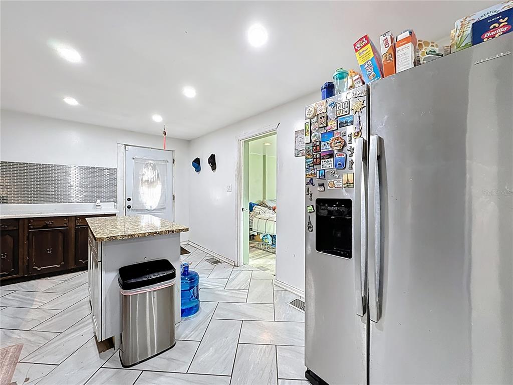 7717 Clarcona Ocoee Road, Unit LOT 1 Orlando, FL 32818 - Photo 16 of 36 a kitchen with a refrigerator and a stove top oven