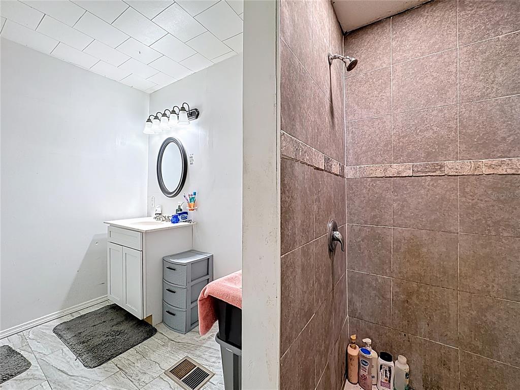 7717 Clarcona Ocoee Road, Unit LOT 1 Orlando, FL 32818 - Photo 25 of 36 a view of a bathroom with sink mirror and shower