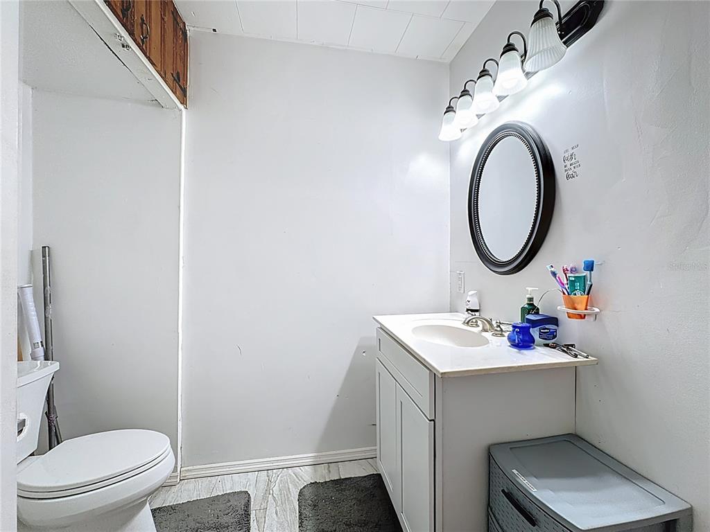 7717 Clarcona Ocoee Road, Unit LOT 1 Orlando, FL 32818 - Photo 26 of 36 a bathroom with a sink toilet and a mirror