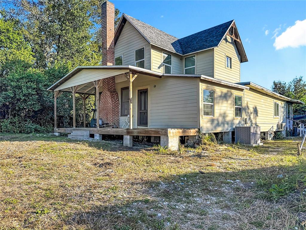 7717 Clarcona Ocoee Road, Unit LOT 1 Orlando, FL 32818 - Photo 3 of 36 a front view of a house with a yard outdoor seating and garage