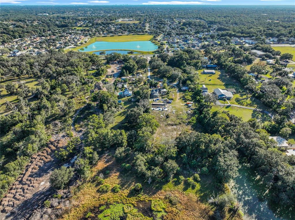 7717 Clarcona Ocoee Road, Unit LOT 1 Orlando, FL 32818 - Photo 6 of 36 an aerial view of residential houses with outdoor space and trees