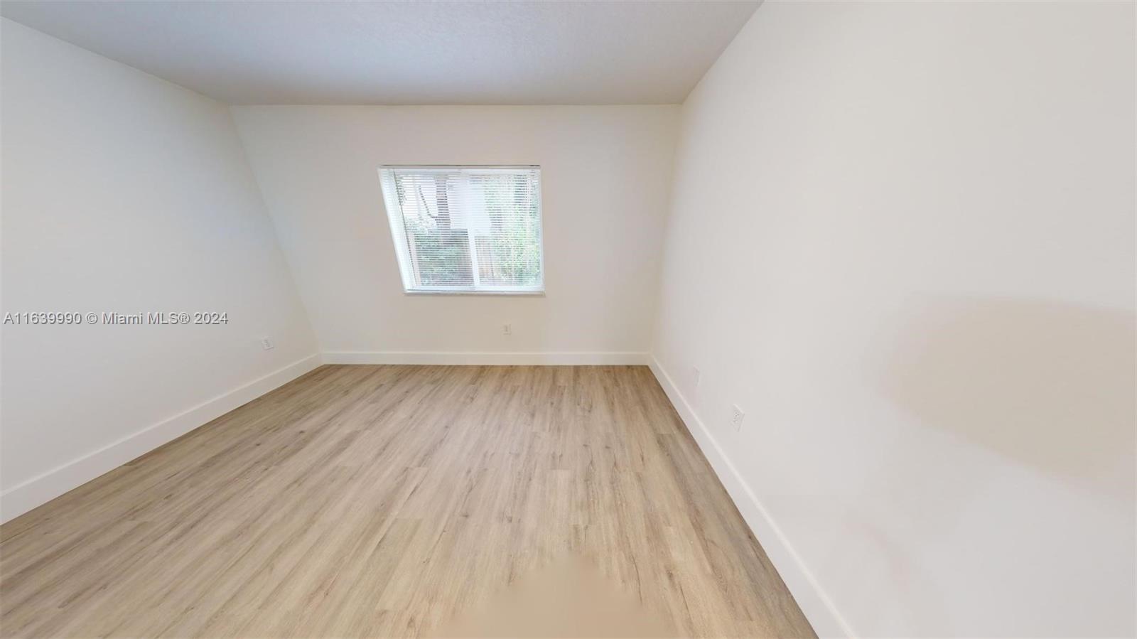 2921 Southeast 13th Road, Unit 10539 Homestead, FL 33035 - Photo 9 of 14 an empty room with wooden floor and windows
