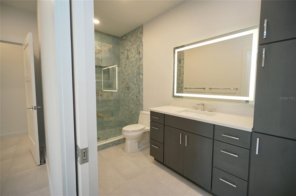 5000 Culbreath Key Way, Unit 9326 Tampa, FL 33611 - Photo 17 of 35 a bathroom with a toilet sink vanity and mirror