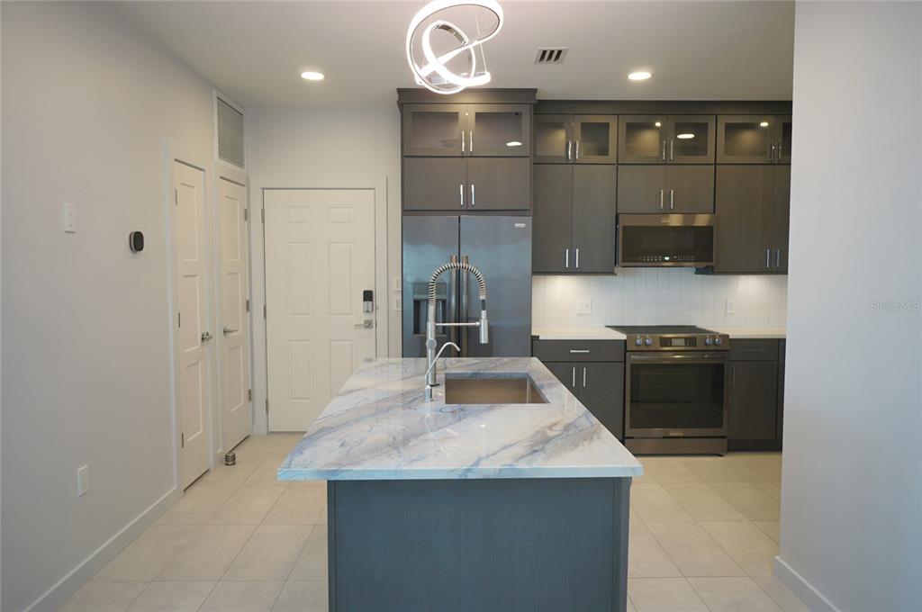5000 Culbreath Key Way, Unit 9326 Tampa, FL 33611 - Photo 4 of 35 a kitchen with kitchen island a counter space appliances and cabinets
