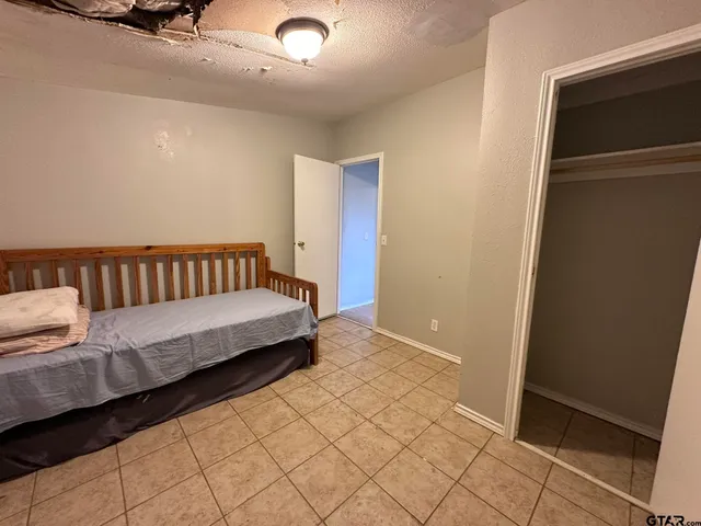 a spacious bedroom with a bed and a shower