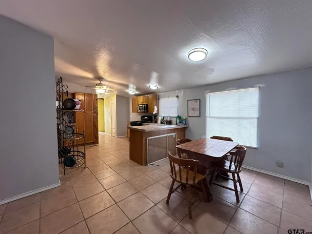 a kitchen with a dining table chairs and white appliances