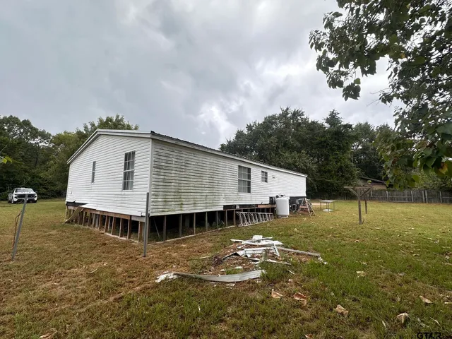 a view of a house with a yard and sitting area
