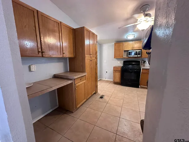 a kitchen with stainless steel appliances granite countertop a stove a refrigerator and a sink with granite countertops