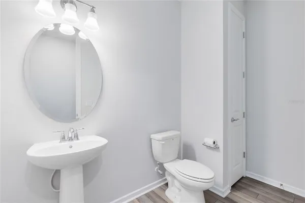 a bathroom with a toilet a sink and mirror