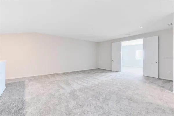 a view of an empty room and chandelier