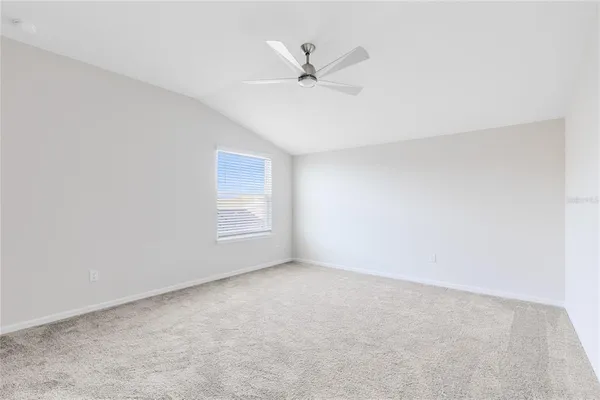 an empty room with a ceiling fan and a window
