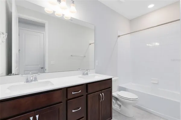 a bathroom with a sink a toilet a mirror and shower