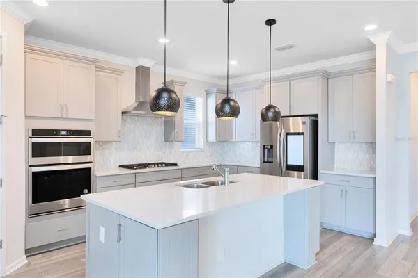 a kitchen with stainless steel appliances granite countertop a sink a stove and a refrigerator