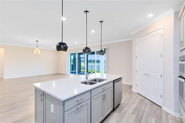 a kitchen with stainless steel appliances granite countertop a sink a window and wooden floor