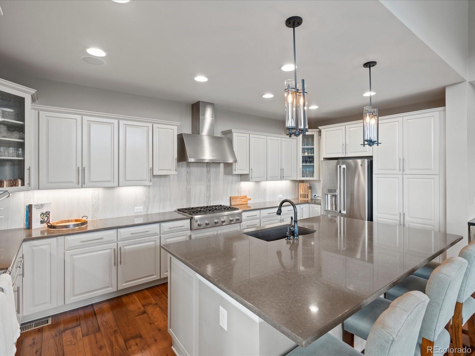 10553 Fairhurst Way Highlands Ranch, CO 80126 - Photo 16 of 35 a kitchen with stainless steel appliances granite countertop a sink a stove and refrigerator