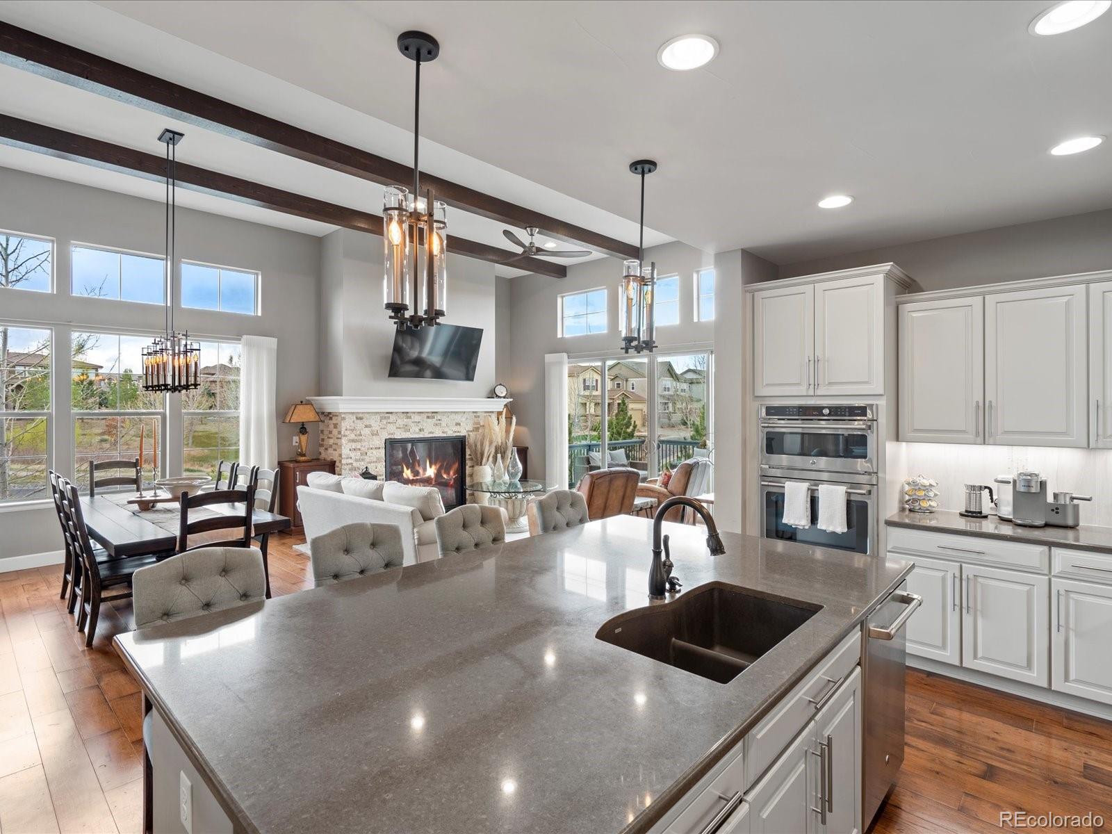 10553 Fairhurst Way Highlands Ranch, CO 80126 - Photo 18 of 35 a kitchen with kitchen island a large counter top space a sink stainless steel appliances and cabinets
