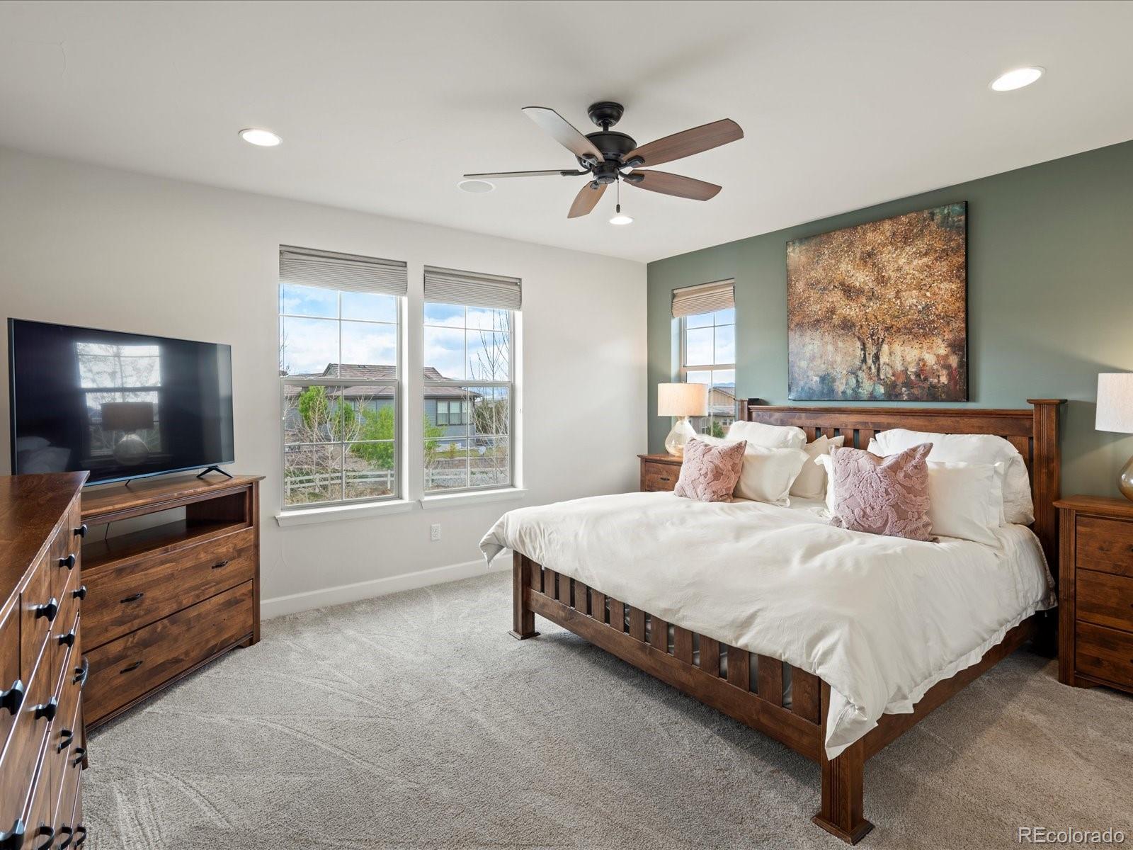 10553 Fairhurst Way Highlands Ranch, CO 80126 - Photo 20 of 35 a spacious bedroom with a bed and a flat screen tv