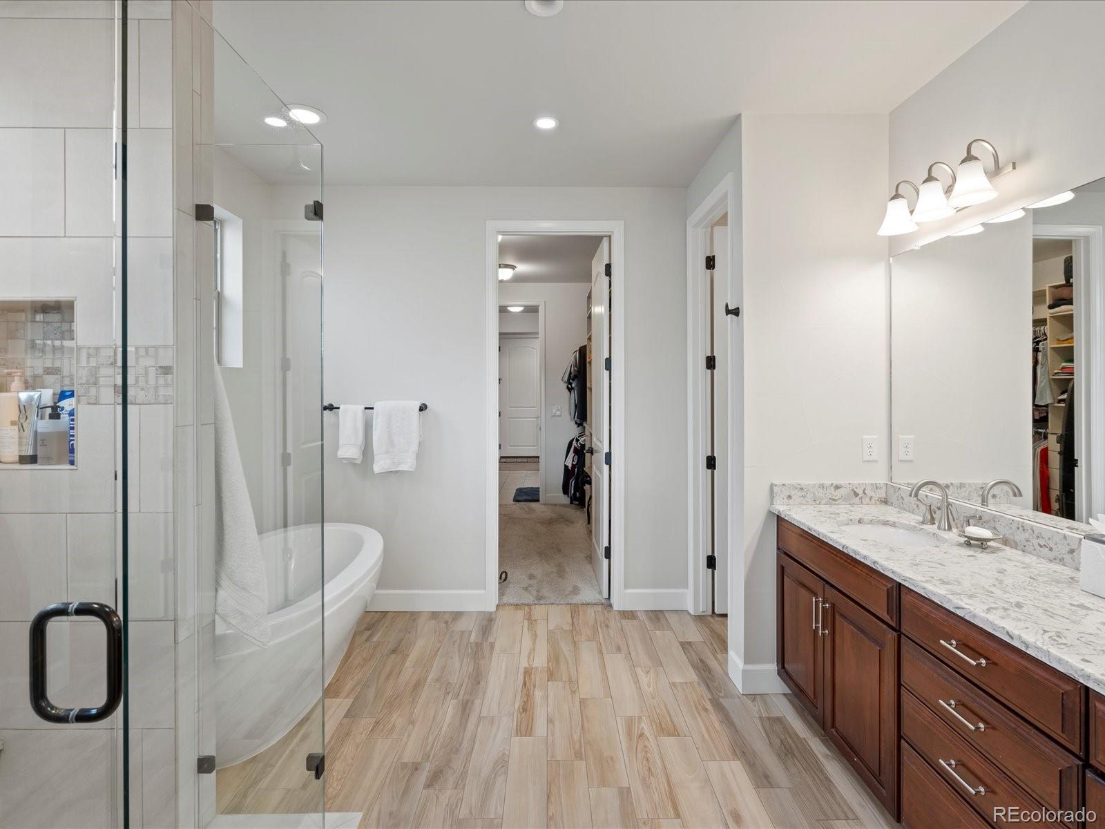 10553 Fairhurst Way Highlands Ranch, CO 80126 - Photo 21 of 35 a bathroom with a double vanity sink a toilet a mirror and shower