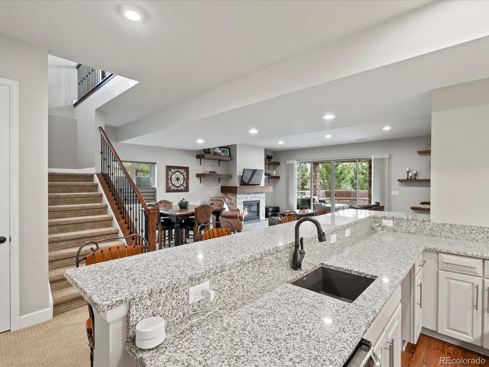 10553 Fairhurst Way Highlands Ranch, CO 80126 - Photo 25 of 35 a kitchen with stainless steel appliances granite countertop a sink a stove and a wooden cabinets