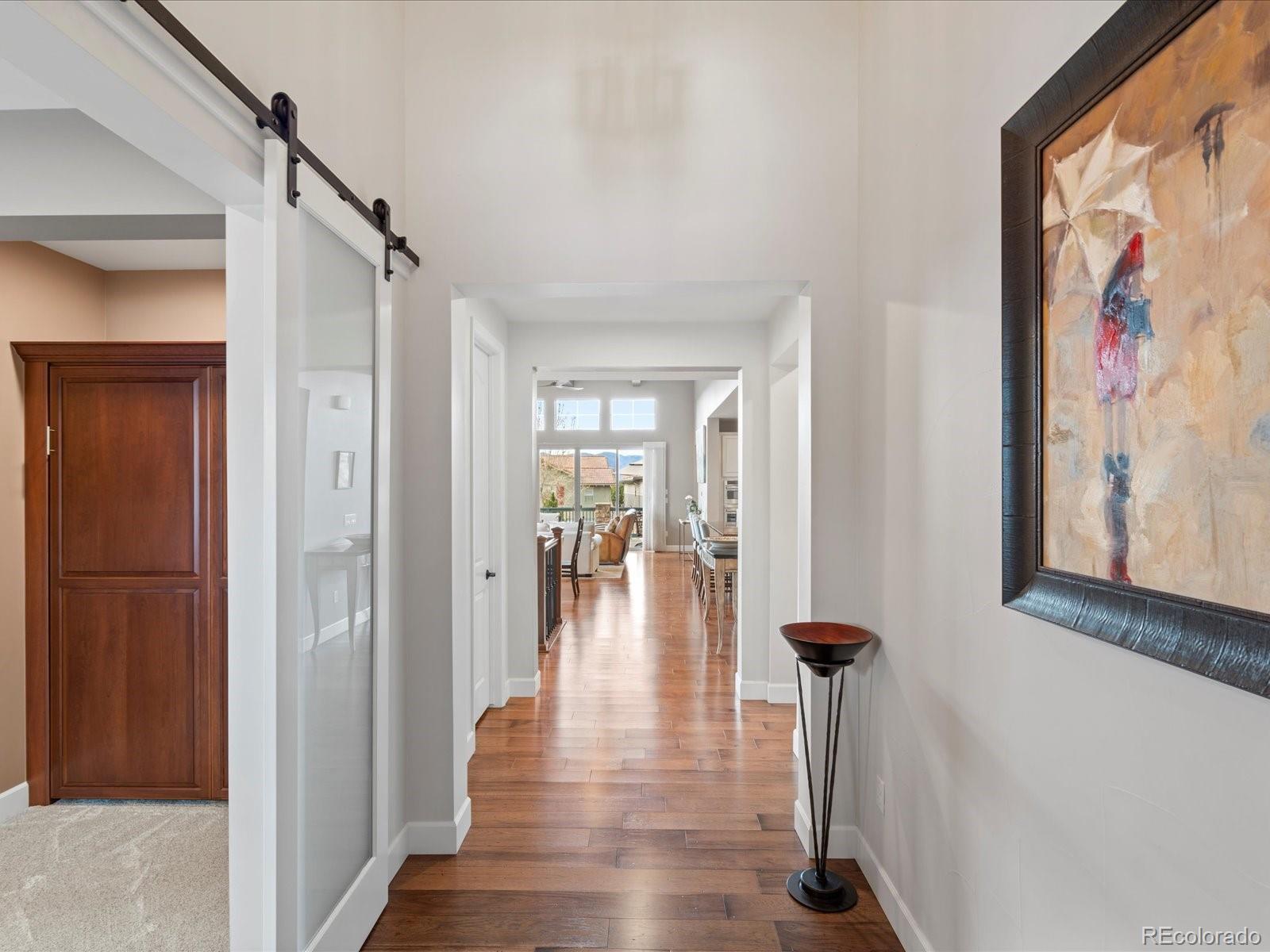 10553 Fairhurst Way Highlands Ranch, CO 80126 - Photo 9 of 35 a view of a hallway with wooden floor and windows