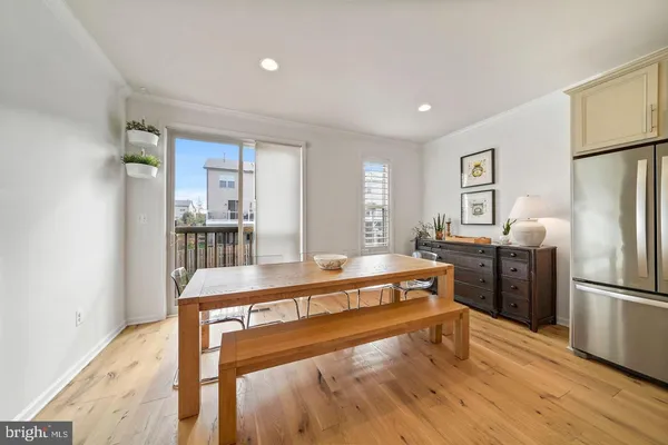 a view of a kitchen with refrigerator and wooden floor