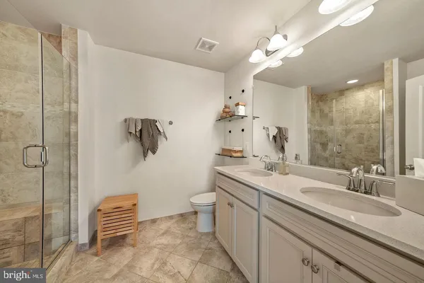 a bathroom with a sink a toilet a mirror and shower