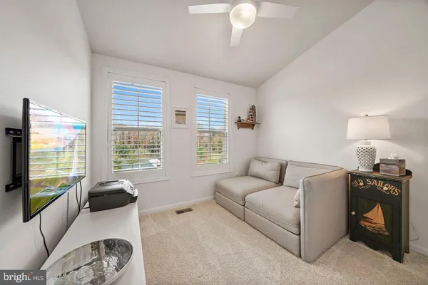 a living room with furniture a window and a flat screen tv