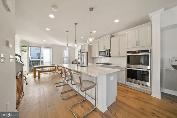 a large white kitchen with lots of counter space a sink and appliances