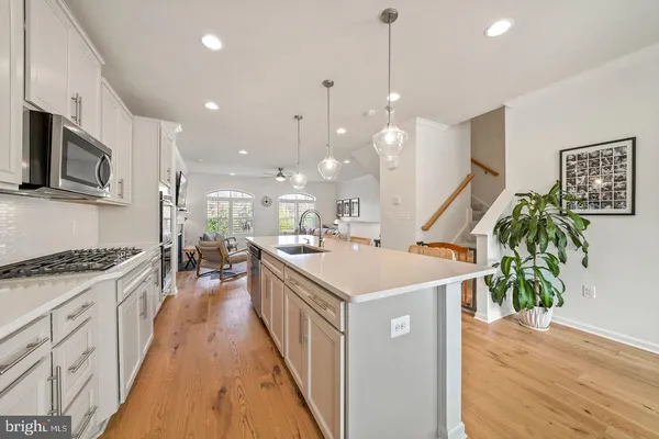 a kitchen with kitchen island a sink appliances and a wooden floor