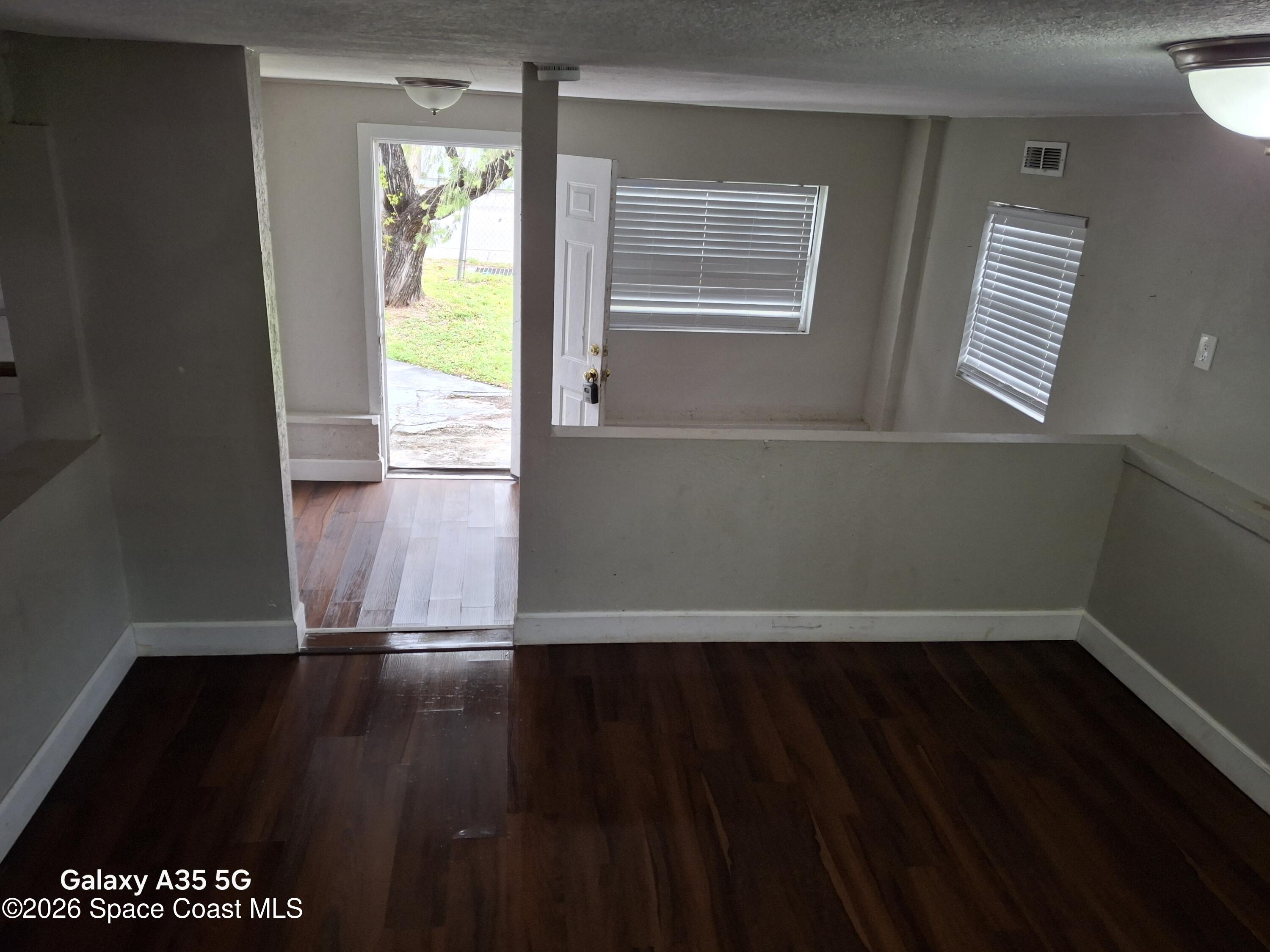 2263 Monroe Street Melbourne, FL 32905 - Photo 3 of 15 a view of an empty room with wooden floor and a window