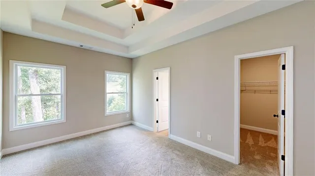 a view of an empty room with window and chandelier fan