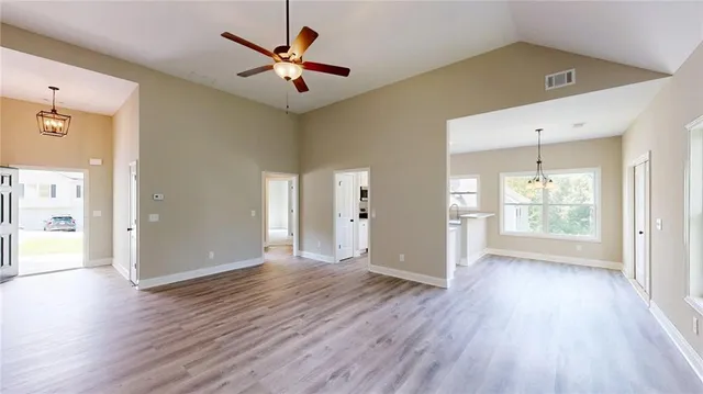 a view of an empty room with window and wooden floor