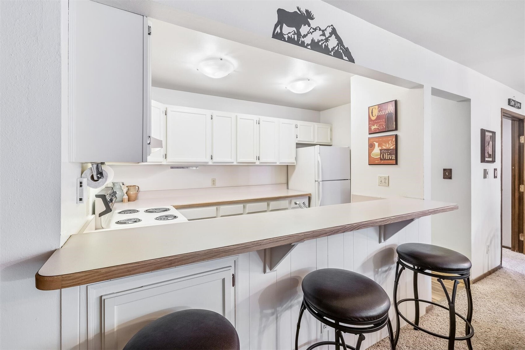 100 Wild Irishman Road, Unit 1103 Keystone, CO 80435 - Photo 6 of 33 Kitchen featuring a breakfast bar area, white appliances, white cabinetry, and light carpet
