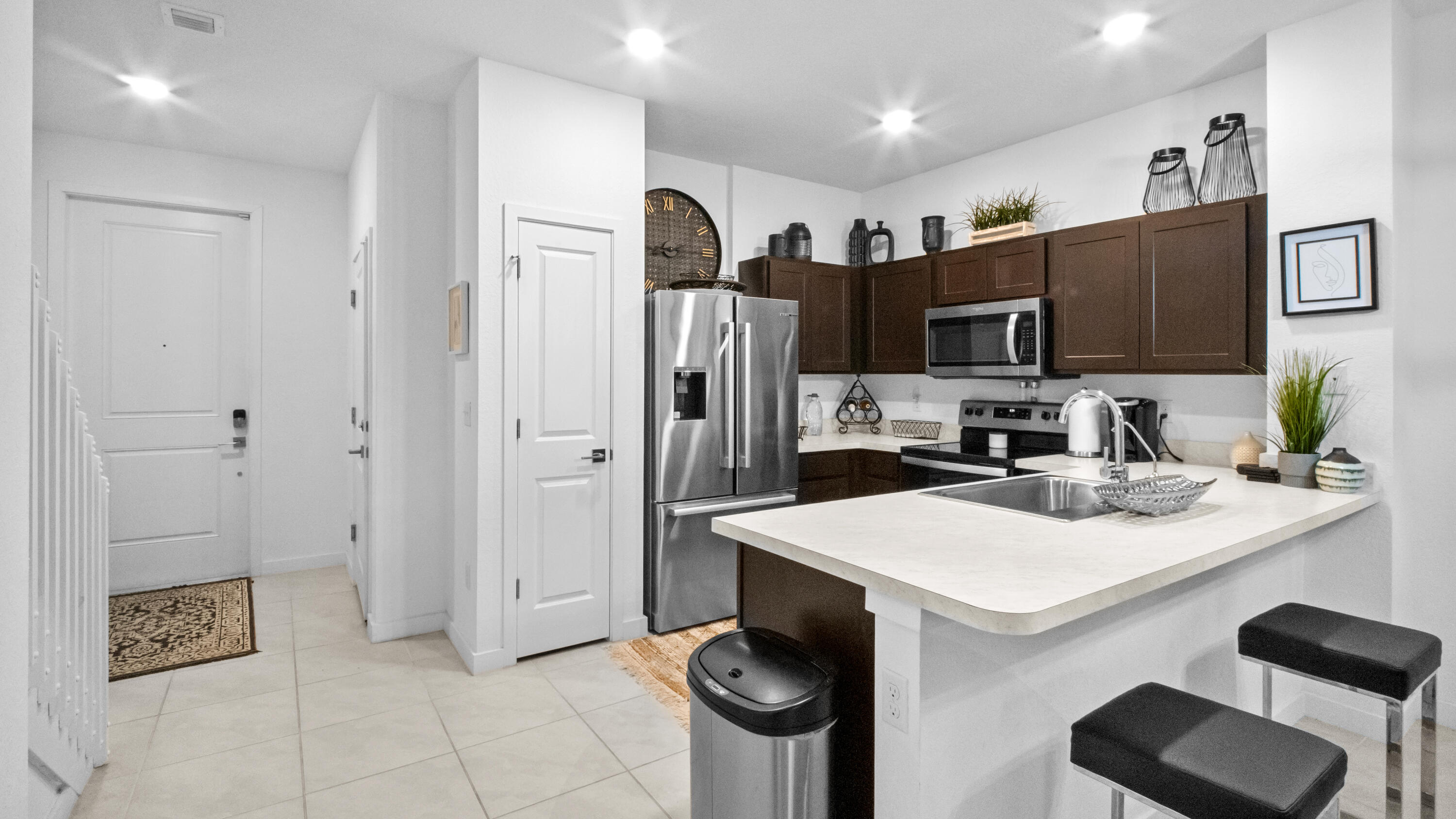 185 Bandol Street Riviera Beach, FL 33404 - Photo 5 of 28 a kitchen with stainless steel appliances a refrigerator stove microwave and sink