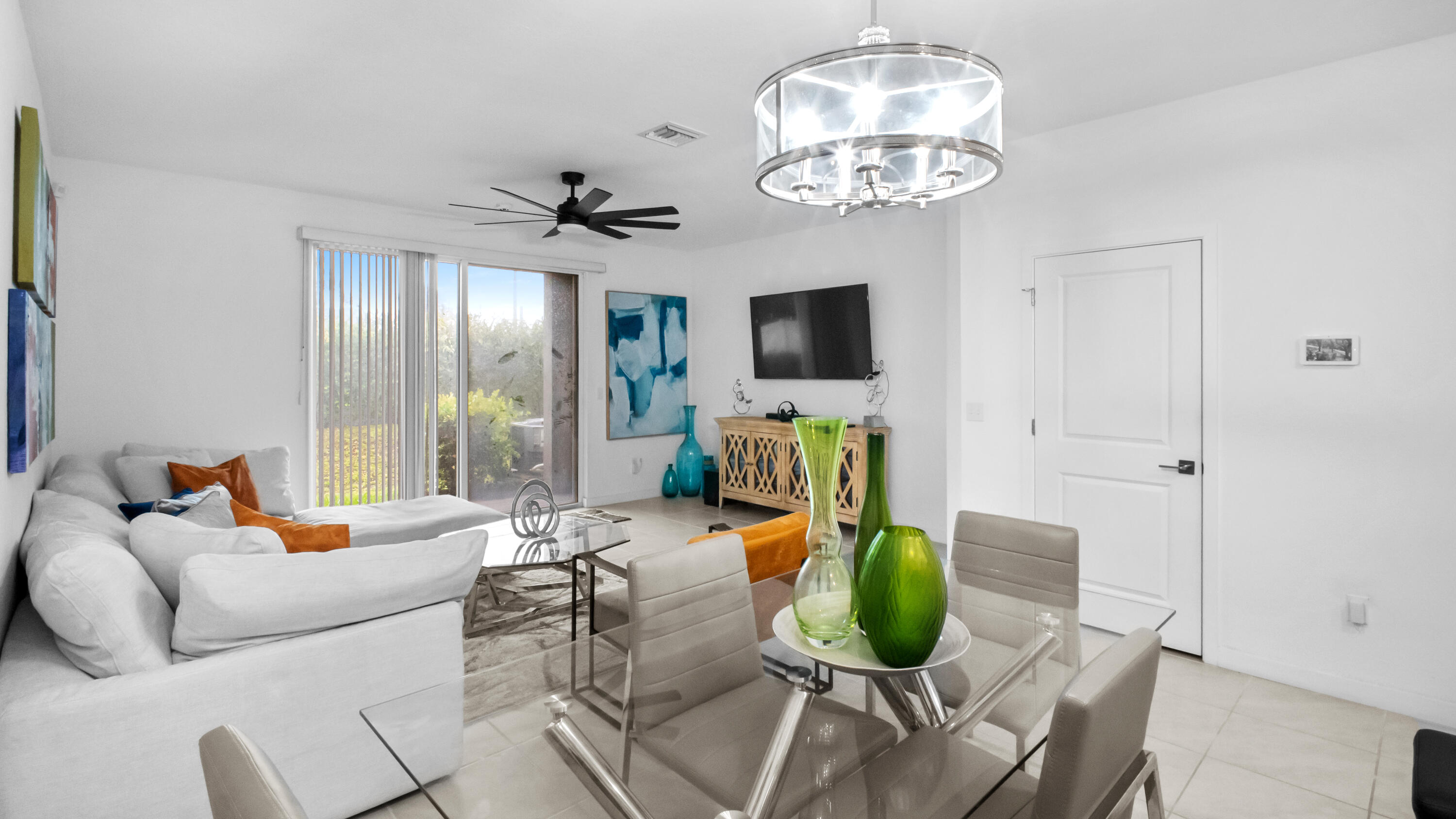 185 Bandol Street Riviera Beach, FL 33404 - Photo 8 of 28 a living room with furniture a chandelier and a flat screen tv