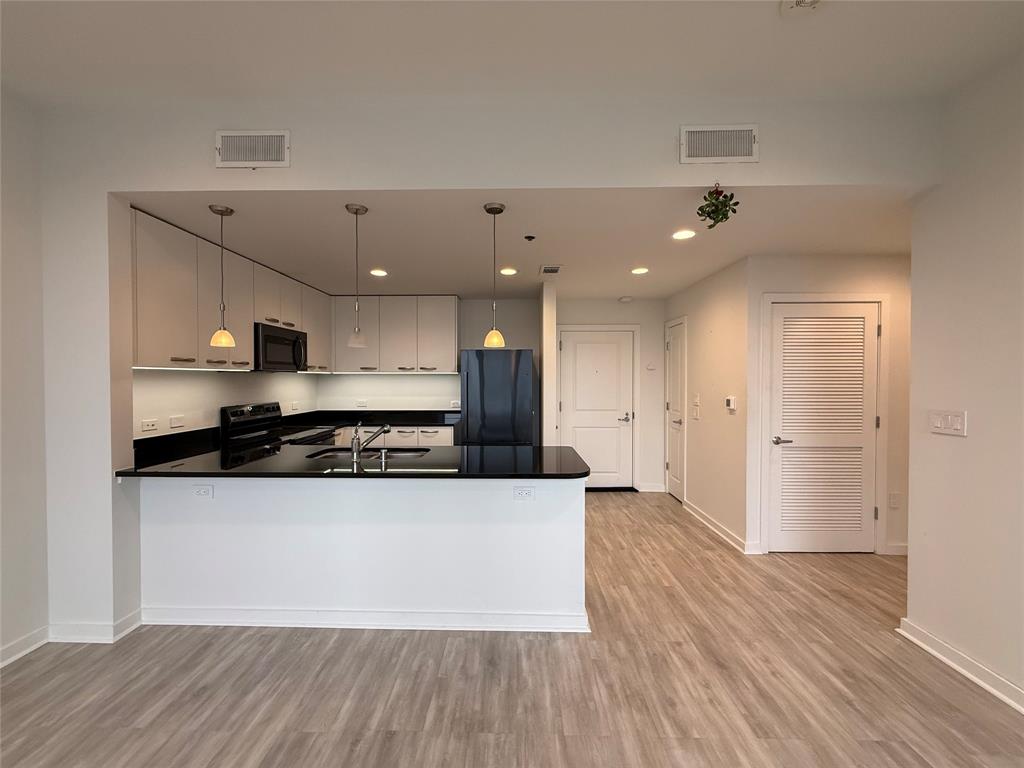1200 Main Street, Unit 902 Dallas, TX 75202 - Photo 12 of 21 a large white kitchen with a sink and stainless steel appliances