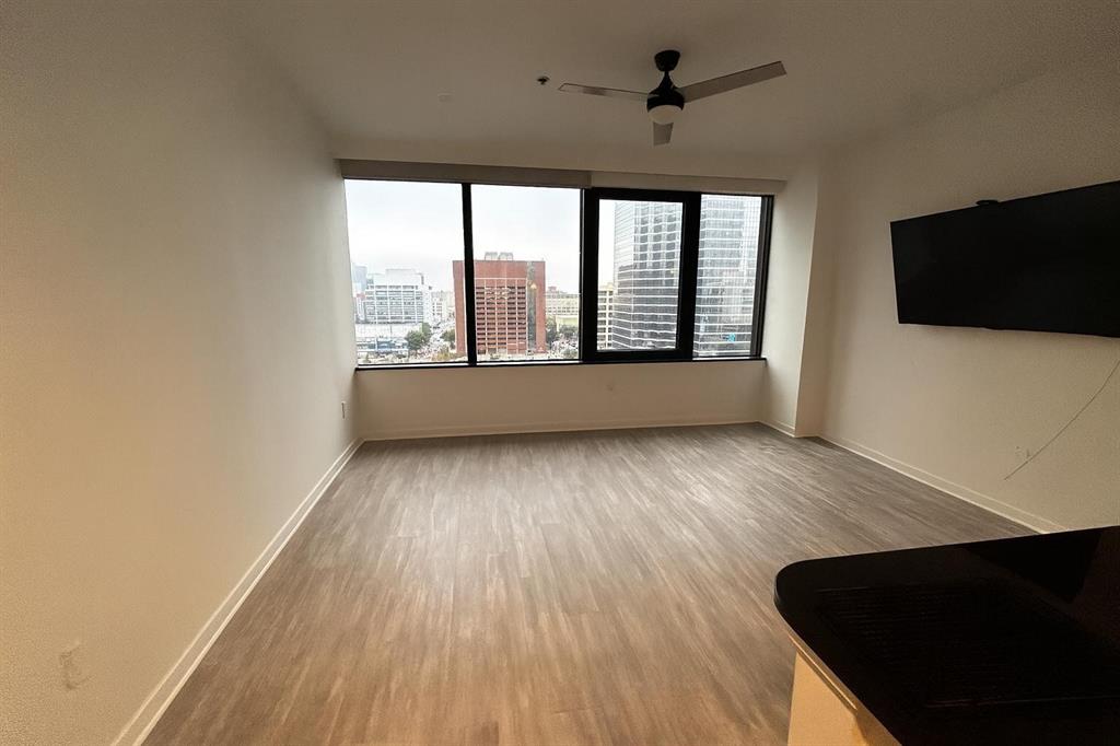 1200 Main Street, Unit 902 Dallas, TX 75202 - Photo 14 of 21 an empty room with wooden floor and windows