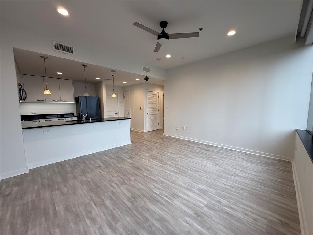 1200 Main Street, Unit 902 Dallas, TX 75202 - Photo 15 of 21 a view of a big room with wooden floor and a ceiling fan