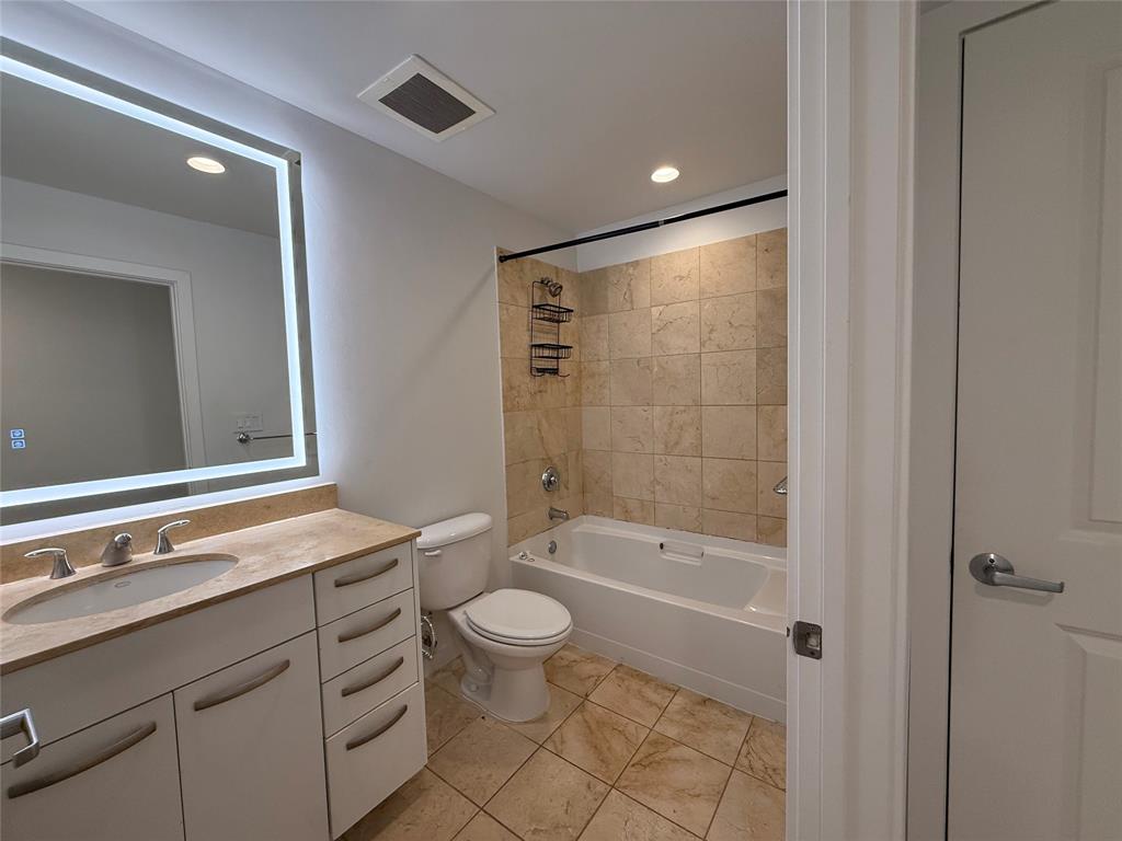 1200 Main Street, Unit 902 Dallas, TX 75202 - Photo 21 of 21 a bathroom with a granite countertop sink a toilet and shower